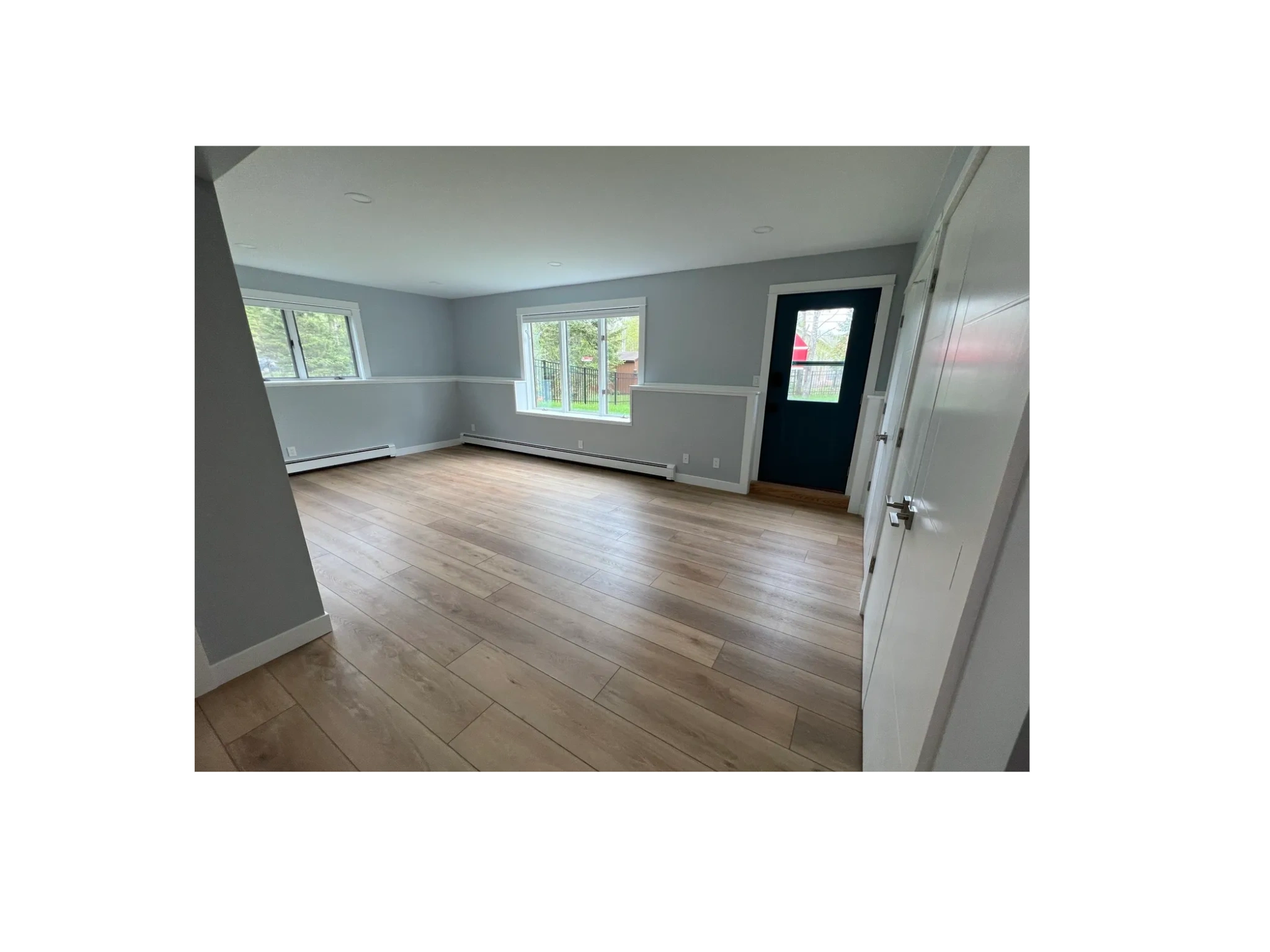 Open room with freshly painted modern gray walls and bright white trim.