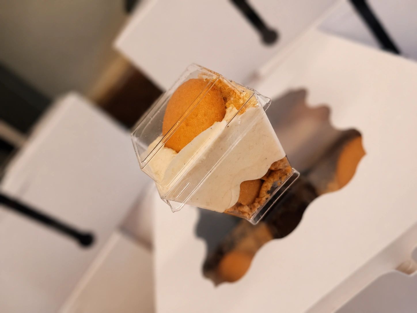 A dessert cup with creamy filling and a round cookie on top.