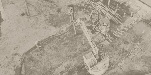 Aerial view of construction site with excavators and foundation work.