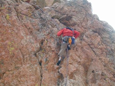 Person climbing a rocky cliff.