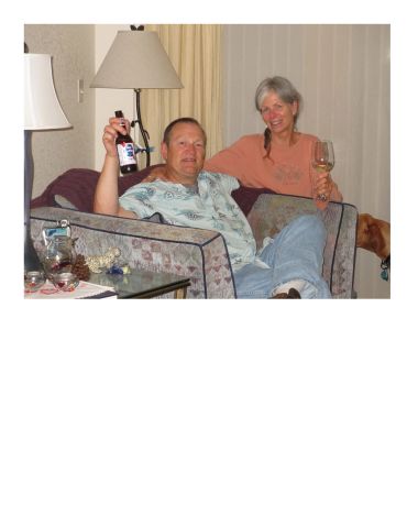 Couple relaxing on a couch with drinks.