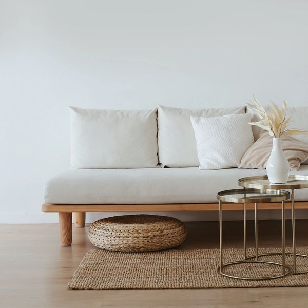 A white couch with metal tables