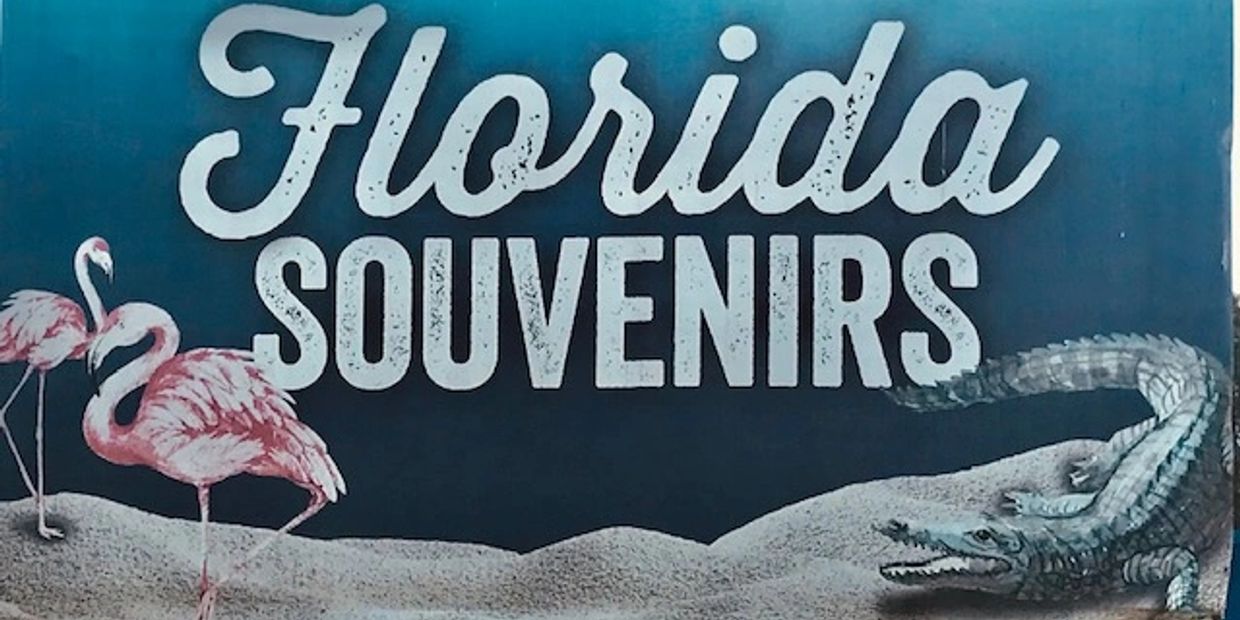 Sign reading 'Florida Souvenirs' with flamingos and an alligator.