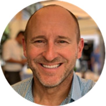 Smiling bald man in a casual setting.