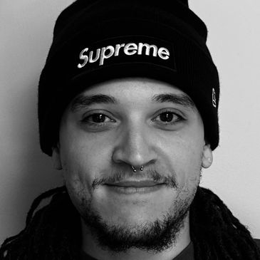 Portrait of a man wearing a Supreme beanie and a septum piercing.