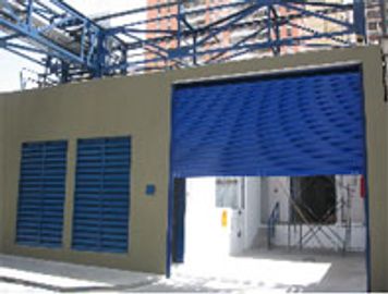 Entrada con puertas metálicas y una persiana azul parcialmente abierta.