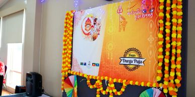 Colorful Durga Puja decoration with marigold garlands and poster.