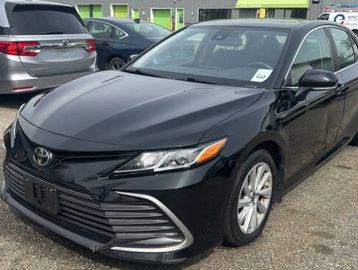 Black Toyota sedan parked in a lot with other cars.