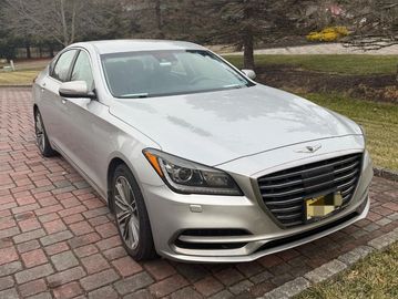 Silver luxury sedan parked on a brick driveway.