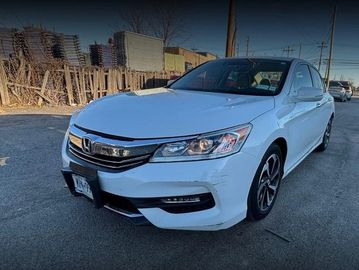 White Honda sedan parked on a street in daylight.