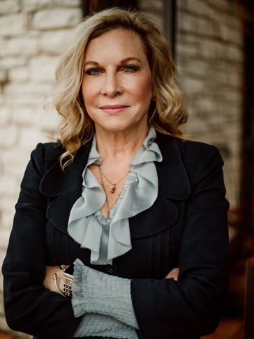 Confident older woman with crossed arms.