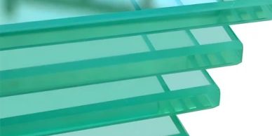 Stack of green glass sheets with smooth edges.