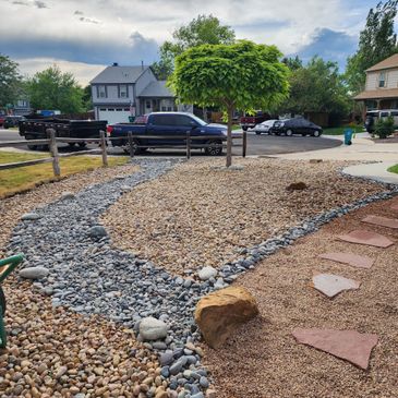 A unique xeriscape designed to emulate a river & provide a variety of depth, dimension, & color.