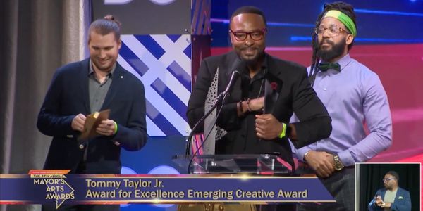 Three men at a podium during the Mayor's Arts Awards ceremony.