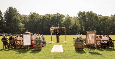 Outdoor wedding ceremony with guests seated in rows.