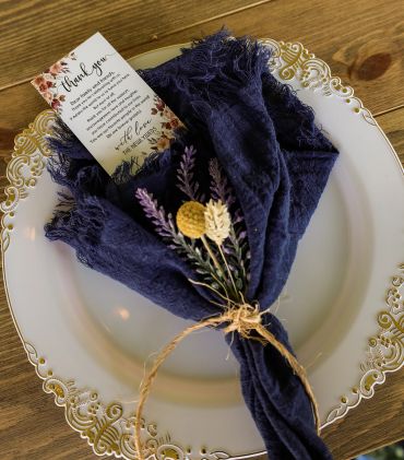 Elegant table setting with a blue napkin and floral decor.