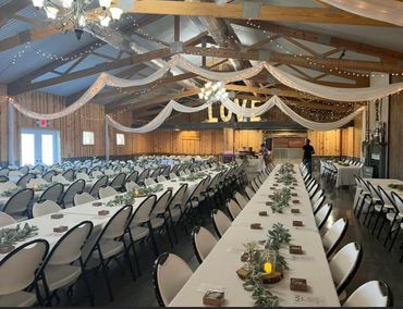 Decorated hall with tables and chairs for an event.