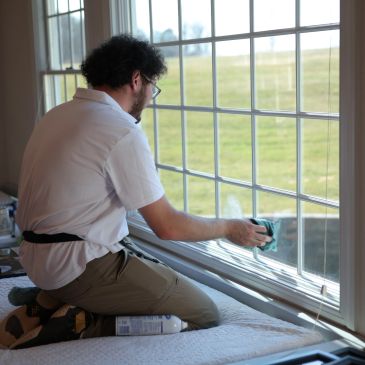 Image of a man cleaning a window with a cloth