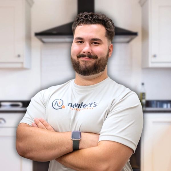 Man standing confidently in a kitchen with crossed arms.