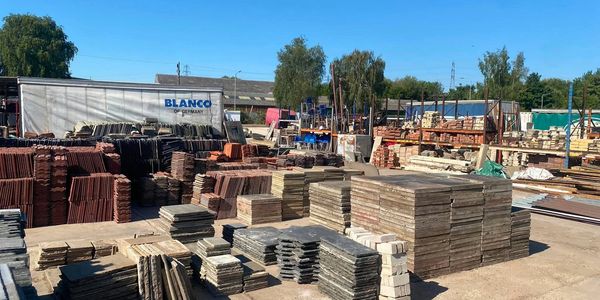 Stacks of tiles and construction materials in a yard.