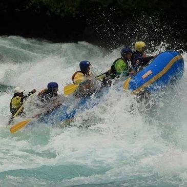 Group white water rafting in rough rapids.