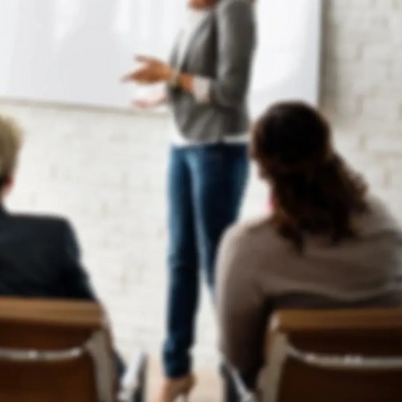 People attending a public speaking training with a speaker at the front.