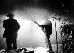 Musicians perform under bright stage lights.


Sources





