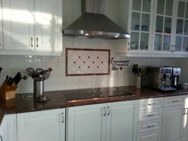Cuisine moderne avec plaques de cuisson et cafetière.