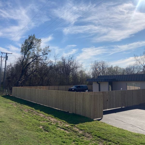 Cedar privacy fence with steel posts and still frame double gates wrap around this business through 