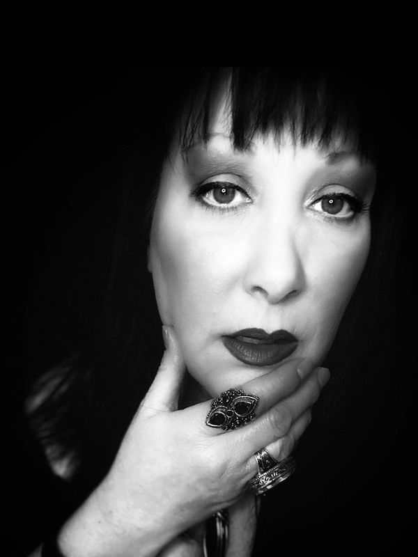 Black and white portrait of a woman with dark lipstick and rings.