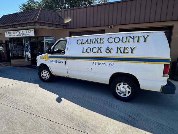 A white locksmith van parked outside a business.