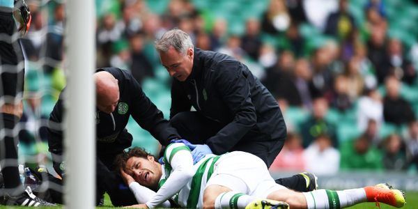 Celtic player Erik Sviatchenko being treated by Tim Williamson and Jonny Gordon