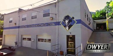 Commercial building for Quality Mechanicals, Inc. with garage doors and signage.