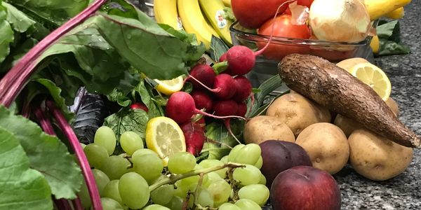 Fresh fruits and vegetables on a black and white granite counter.