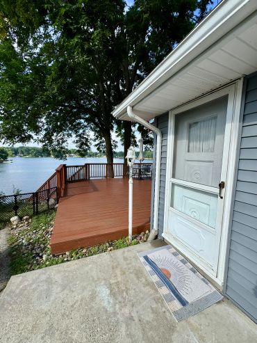 Lakefront deck and house entrance on a sunny day.