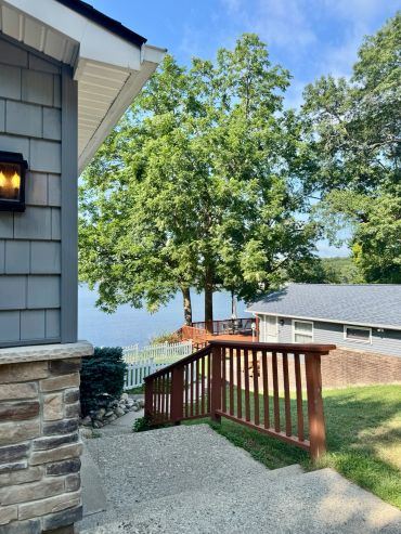 View of backyard stairs leading to lake and trees.
