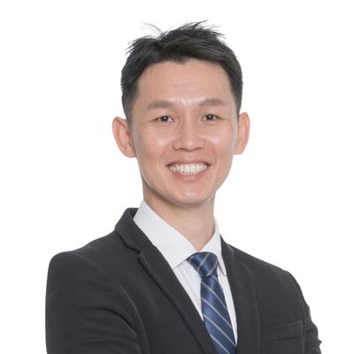 Smiling man in formal suit with striped tie against white background.