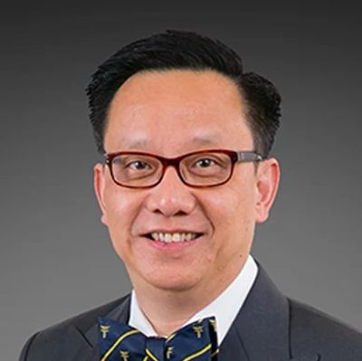 Portrait of a smiling man wearing glasses and a bow tie.