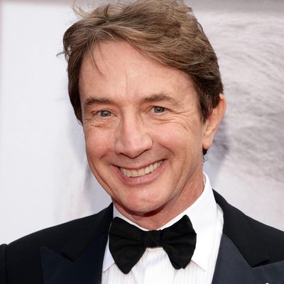 A smiling man in a tuxedo with a black bow tie.