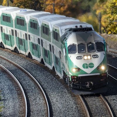 A GO Transit double-decker train traveling on curved tracks.