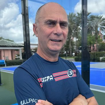 Man posing outdoors on a tennis court.