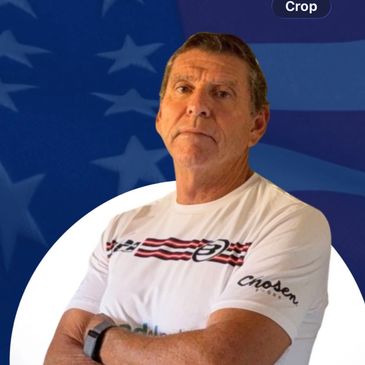 Man in white shirt posing with crossed arms.