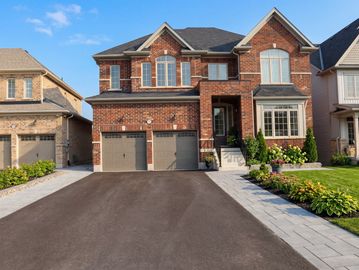 Large brick two-story house with a double garage and well-kept driveway.