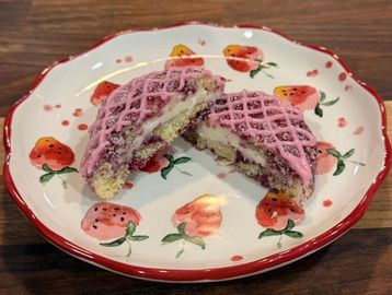 Two halves of a pink pastry on a floral plate.