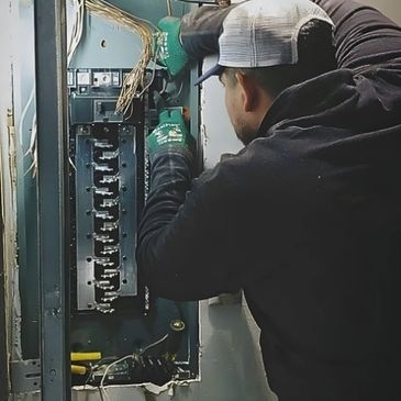 Man wiring a electrical panel.