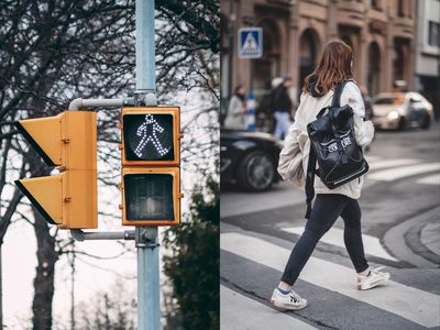 Picture of a crosswalk light and a person walking in a crosswalk.