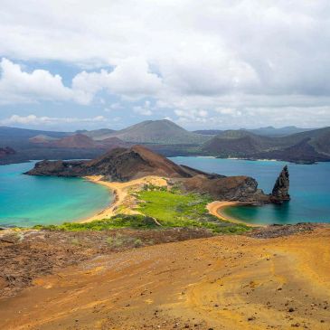 Scenic view of a volcanic island with turquoise waters and rugged terrain.
