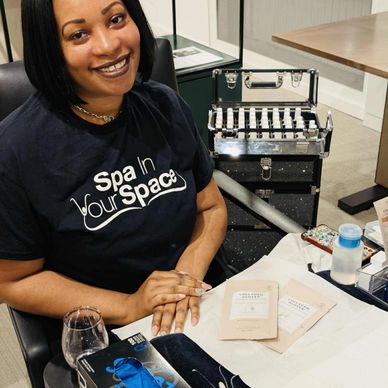 Smiling woman at a spa manicure station with nail care products.