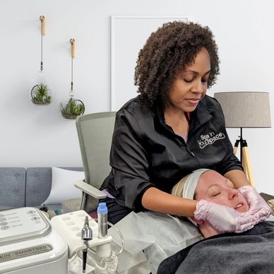 A skincare specialist performs a facial treatment on a client in a modern spa.