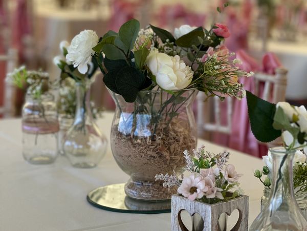 Elegant floral centerpiece on a table with rustic and delicate flowers.